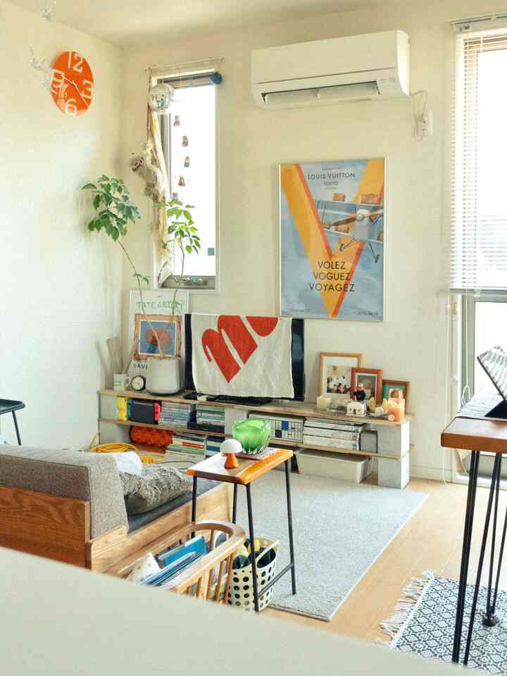 白い壁と木目調家具が特徴の北欧ミッドセンチュリーモダンなリビングルーム、ソファとテレビ台が配置された印象的な空間