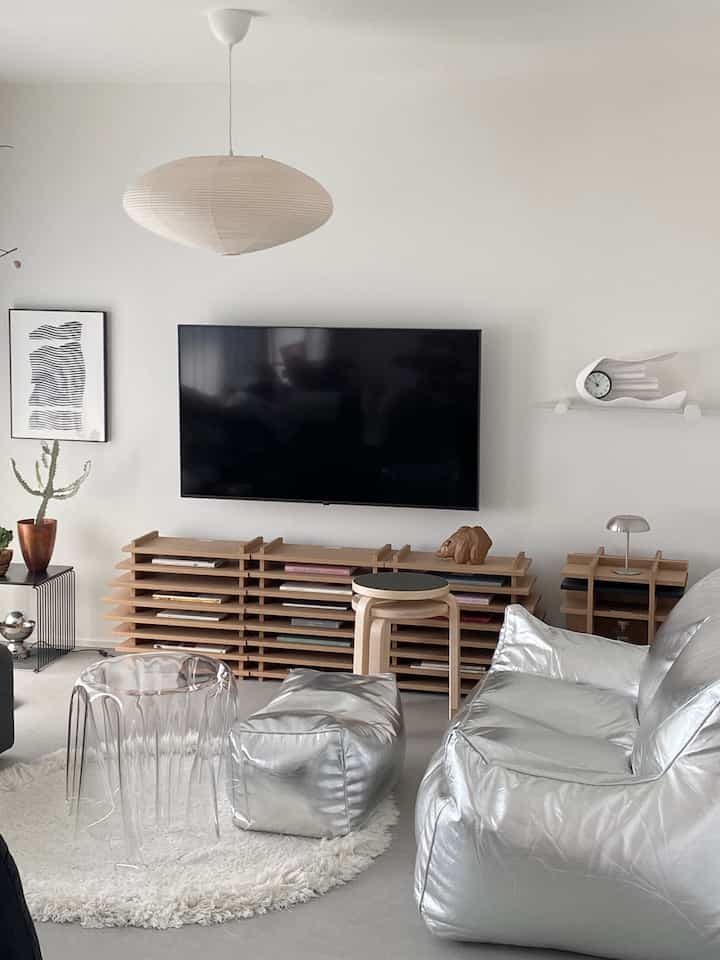 White walls with natural modern wooden TV stand, silver bean bag sofa and transparent coffee table in a stylish living room