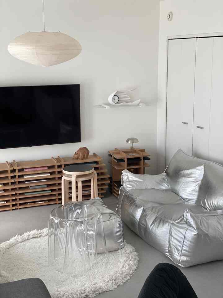 白い壁と天井、シルバーのビーズクッションが配置されたモダンな二人暮らしのリビングスペース