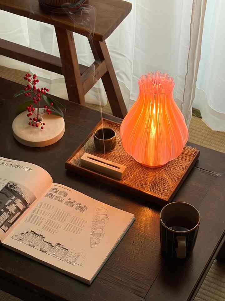 暖かいオレンジ色の照明があるダークウッドのテーブルが配置された居心地の良いダイニングスペース