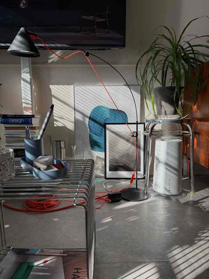 A modern living space featuring silver stainless stools and plants with natural tones harmonizing the atmosphere