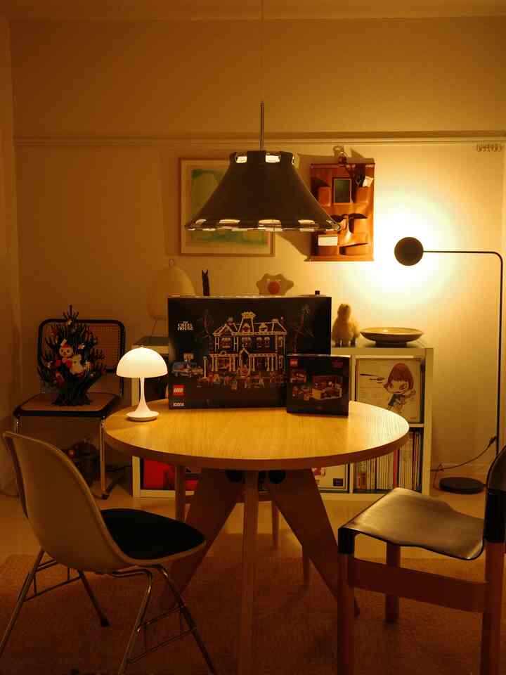 温かみのあるライトブラウンのダイニングルーム、木製テーブルと照明、かわいらしいオブジェが配置された雰囲気のあるインテリア