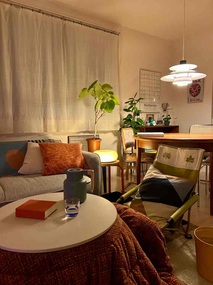 Warm light brown and gray toned living room featuring mid-century modern furniture and pendant lighting creating a cozy atmosphere