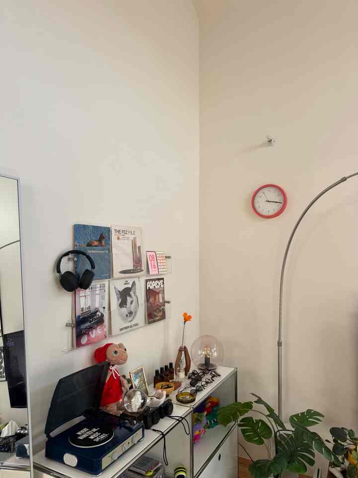 White wall corner in a mid-century modern style room featuring a record player and wall-mounted vinyl records display with cozy decor
