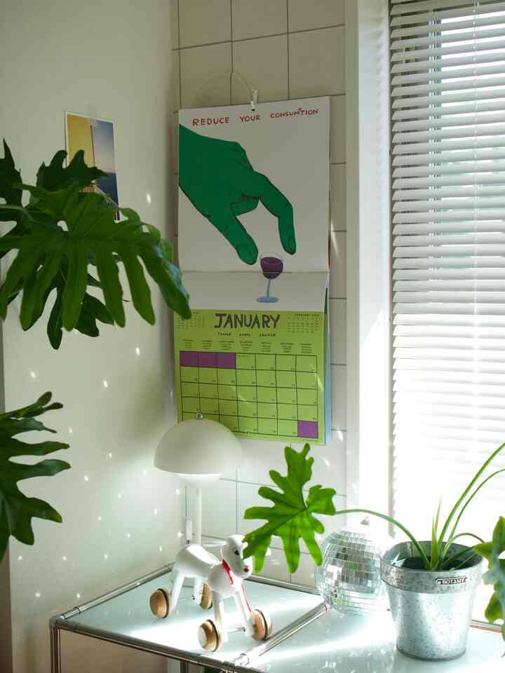 白と緑のトーンが調和した小さな空間、テーブル上に犬の玩具と植物が配置された明るく清潔感のあるインテリア