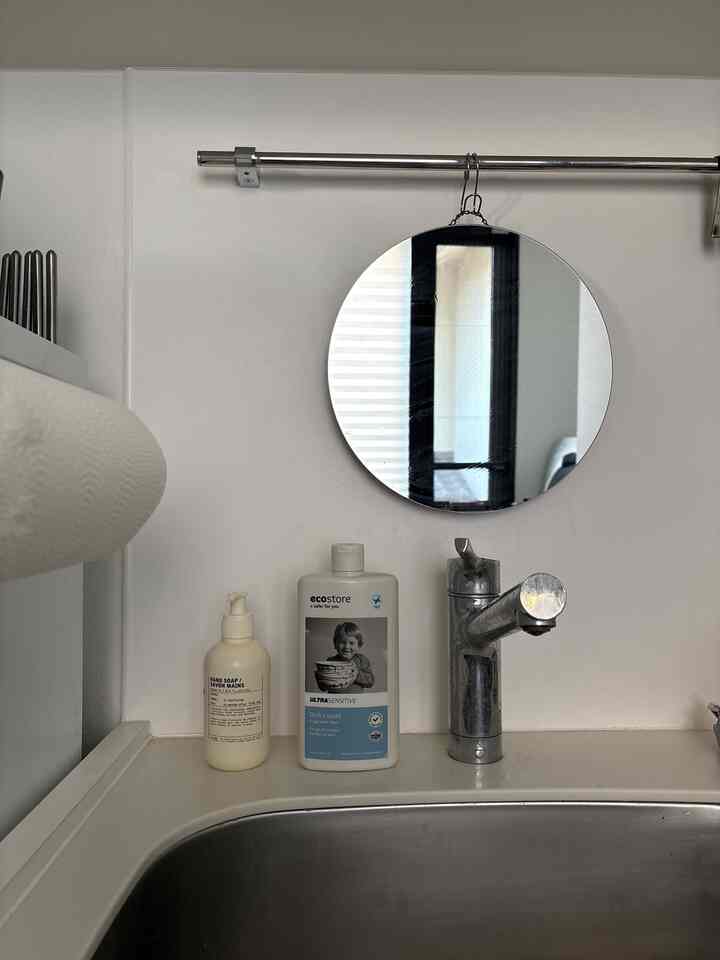 ナチュラルカラーのキッチン、シンクとハンドソープ、エコストアの食器用洗剤が配置されたシンプルな空間