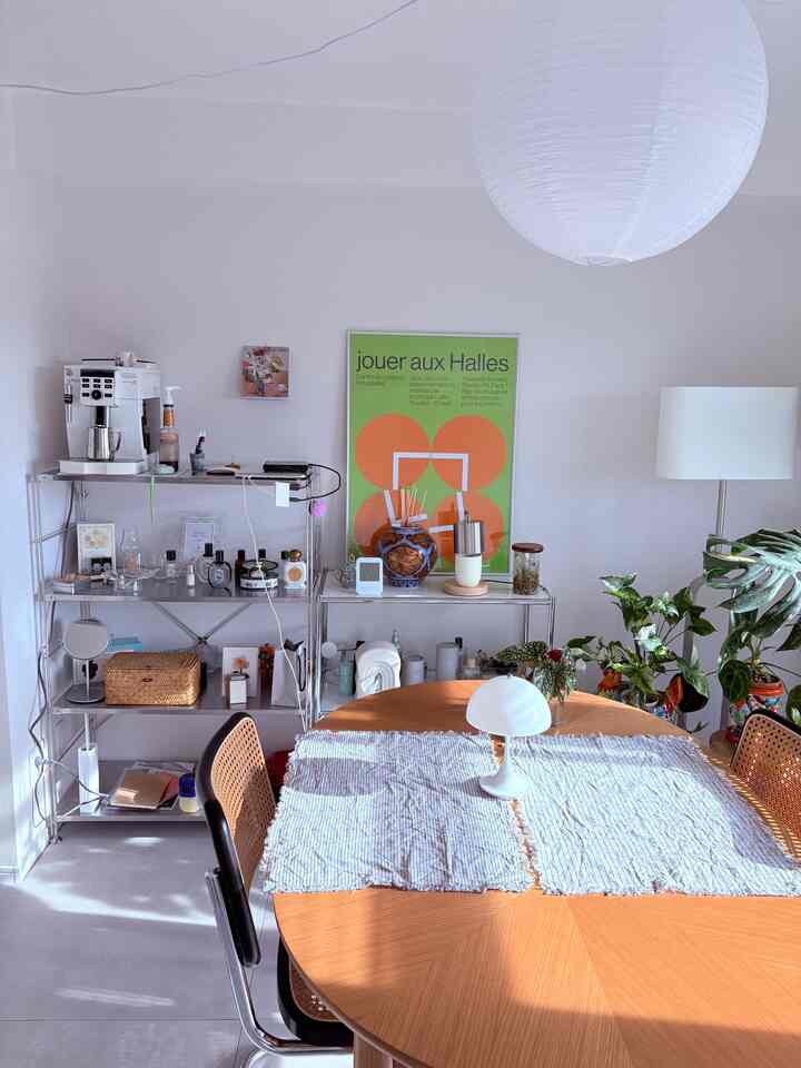 温かみのある木目調が特徴のミッドセンチュリーモダンなダイニング、丸テーブル、観葉植物、フロアランプが配された印象的な空間