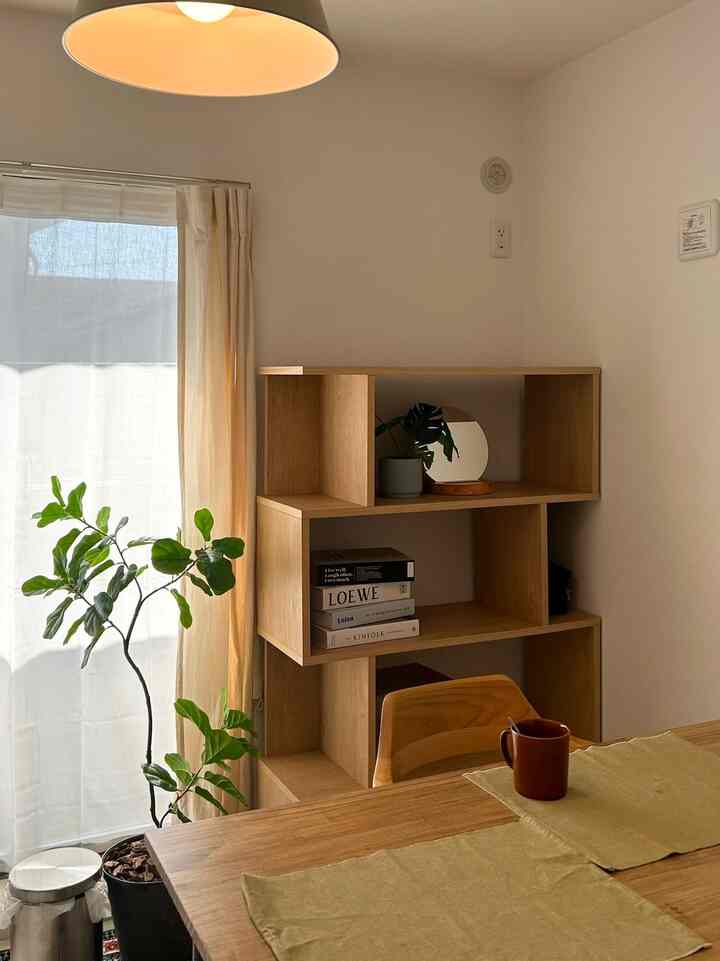 ベージュと木目調で暖かい雰囲気のダイニング、ダイニングテーブルと椅子、植物が配置されたシンプルな空間