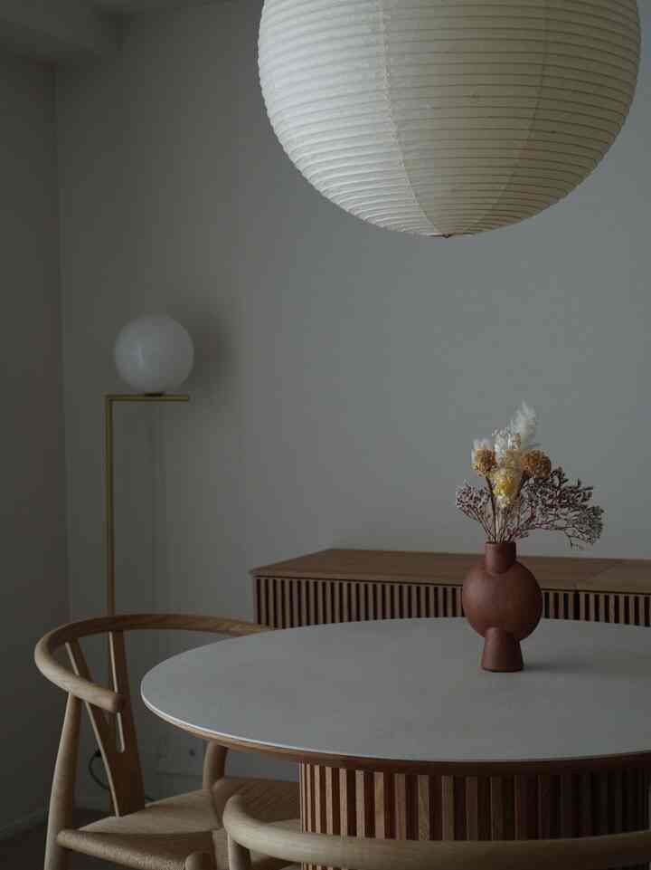 木目調と白を基調としたシンプルなリビングのダイニング空間、丸いテーブルとすっきりとした家具が印象的なインテリア。