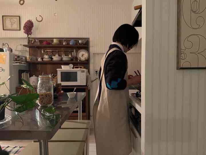 ナチュラルで白を基調としたキッチン、メタルのダイニングテーブルとウッドの棚が配置された雰囲気のあるインテリア