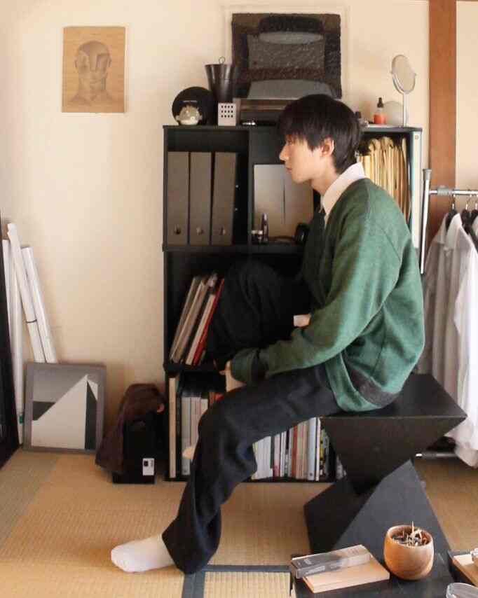 ナチュラルトーンの1人暮らし向けコンパクトな畳の部屋、黒い家具と本棚が配置された雰囲気のあるインテリア