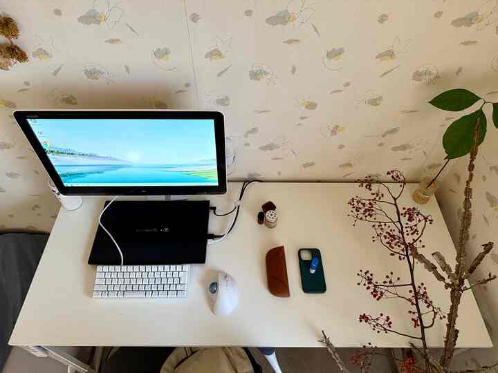 白を基調としたホームオフィス、ミニマルなデスクにモニターとトラックボールマウスが配置された雰囲気のあるインテリア