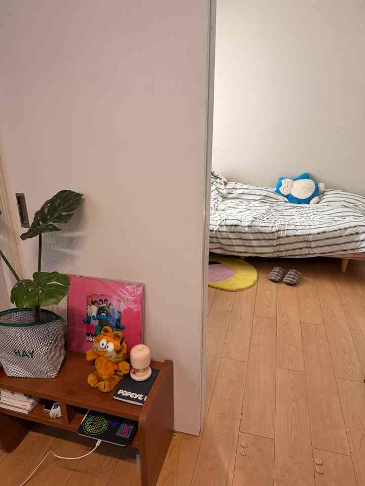 White and natural toned bedroom featuring a striped bed and yellow rug, creating a cozy and harmonious space