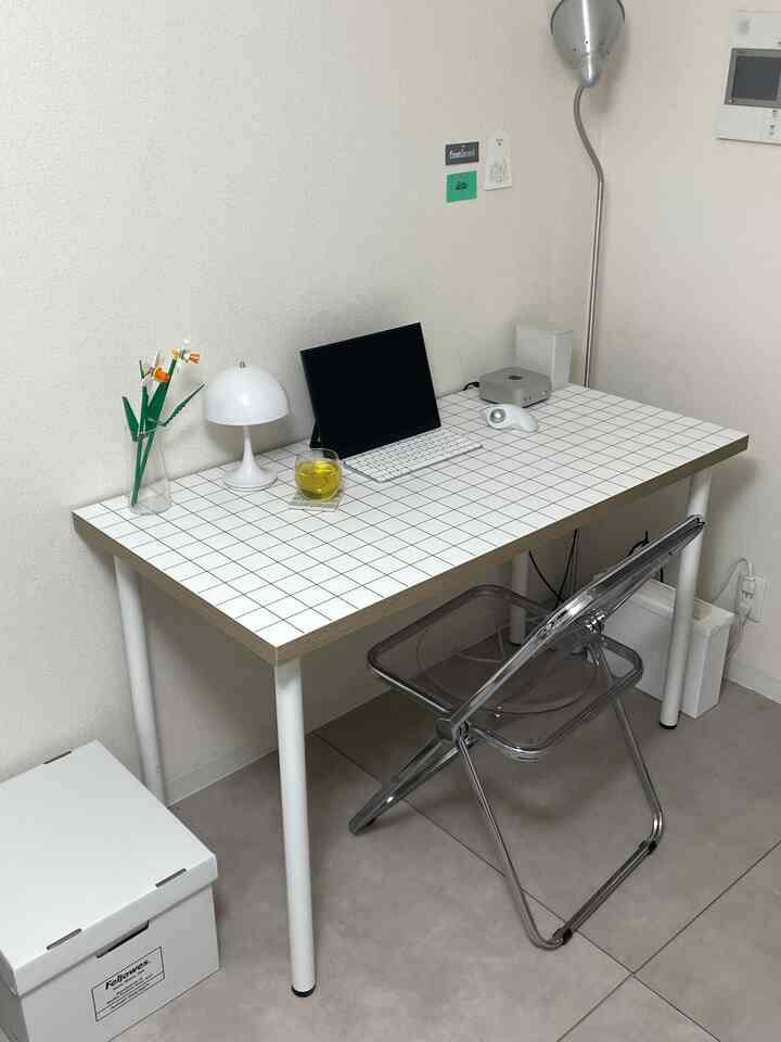 ホワイトと透明素材が調和した一人暮らしの1Kワンルームのデスク空間、清潔感とシンプルさが際立つ雰囲気