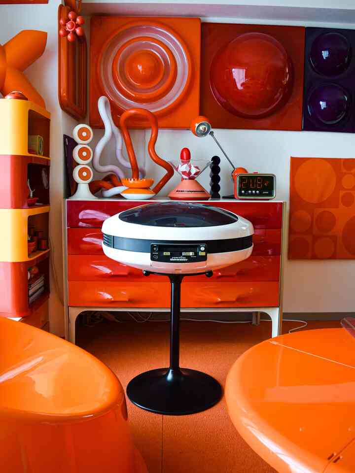 鮮やかなオレンジ色のダイニングルーム、ミッドセンチュリーモダン家具と昭和レトロな装飾が配置された活気のある空間