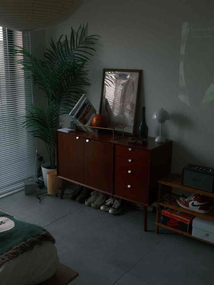 木目調と白を基調とした寝室、キャビネットとシューズラックが配置された居心地の良い一人暮らしの空間