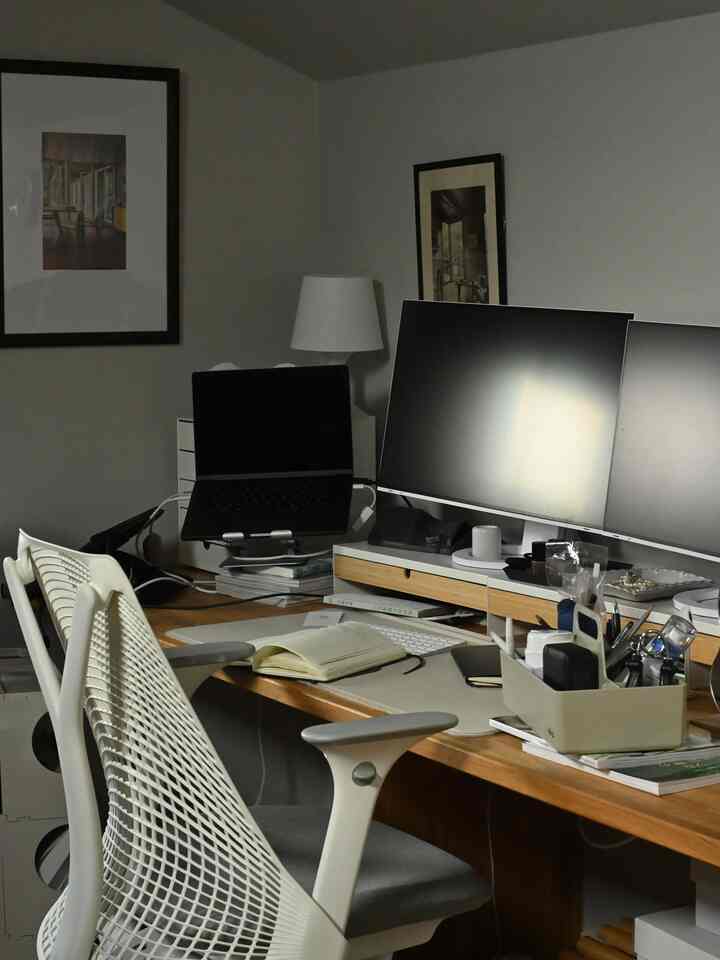 White and brown toned workspace featuring dual monitors and office chairs in a tidy remote work setup