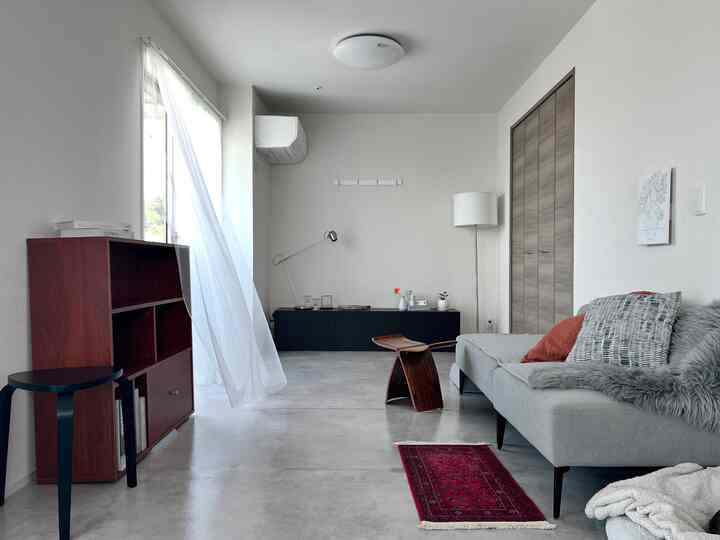 Bright white and navy toned living room featuring a minimalist sofa and wooden furniture with a calm, clean atmosphere