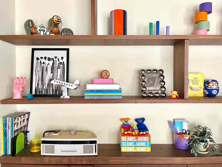 木目調の棚にカラフルなおもちゃとインテリア小物が配置された雰囲気のあるリビング