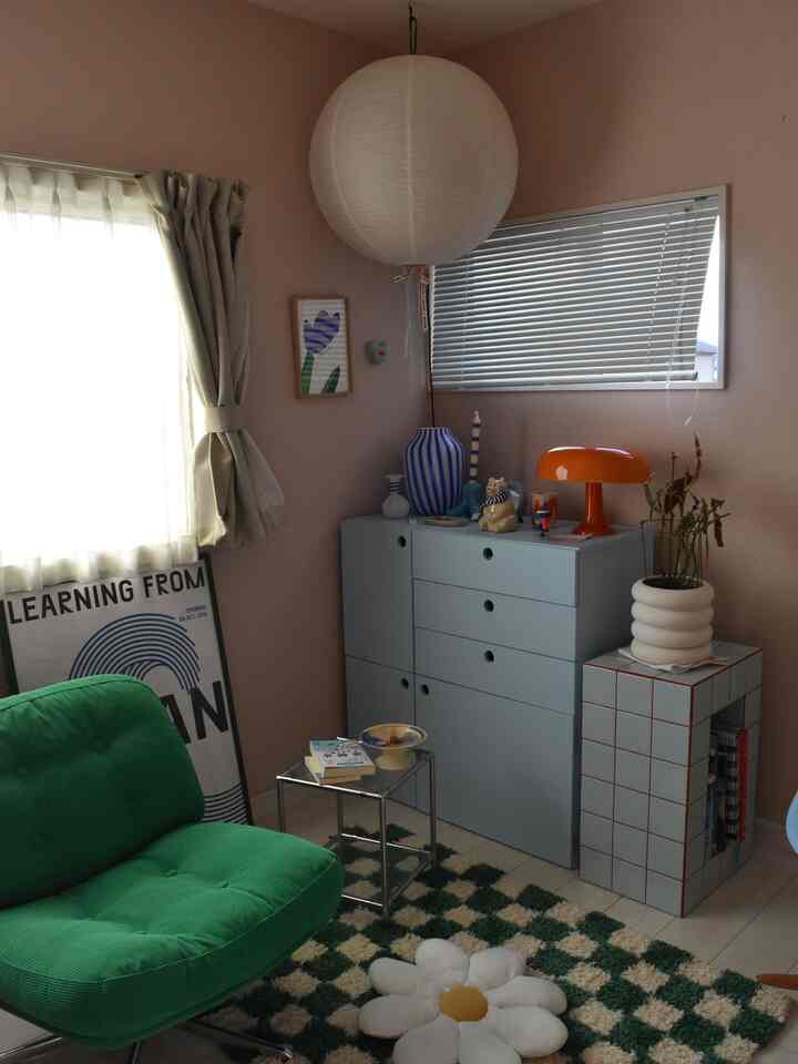 明るい白い壁と天井、緑のソファとパターンカーペットが配置された居心地の良いリビングルーム