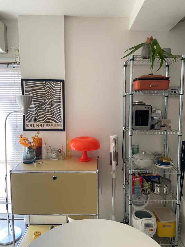 White and ivory toned 1DK small room featuring mid-century modern lamp and steel shelving with a clean atmosphere
