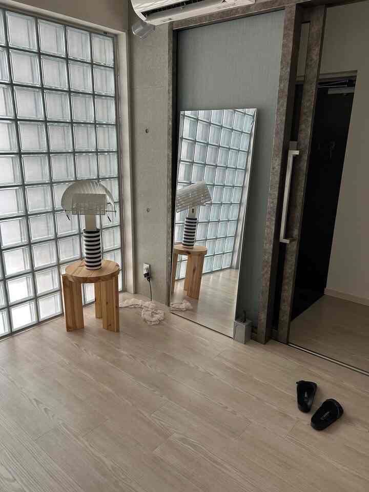 Bright wood-toned minimal modern interior space featuring a natural wood stool and unique lighting with a relaxed atmosphere