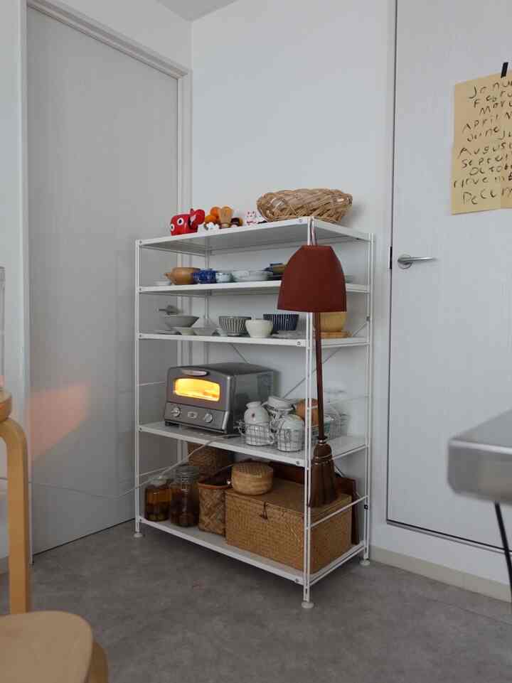 白い壁と棚があるキッチン空間、トースターと様々な食器が整然と配置された雰囲気のあるインテリア