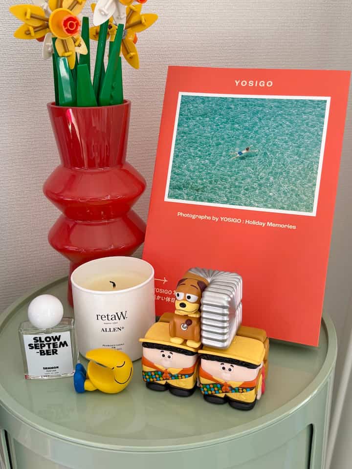 赤と黄色のトーンが特徴的なインテリア、小物やフィギュアが配置された印象的なテーブル上の空間