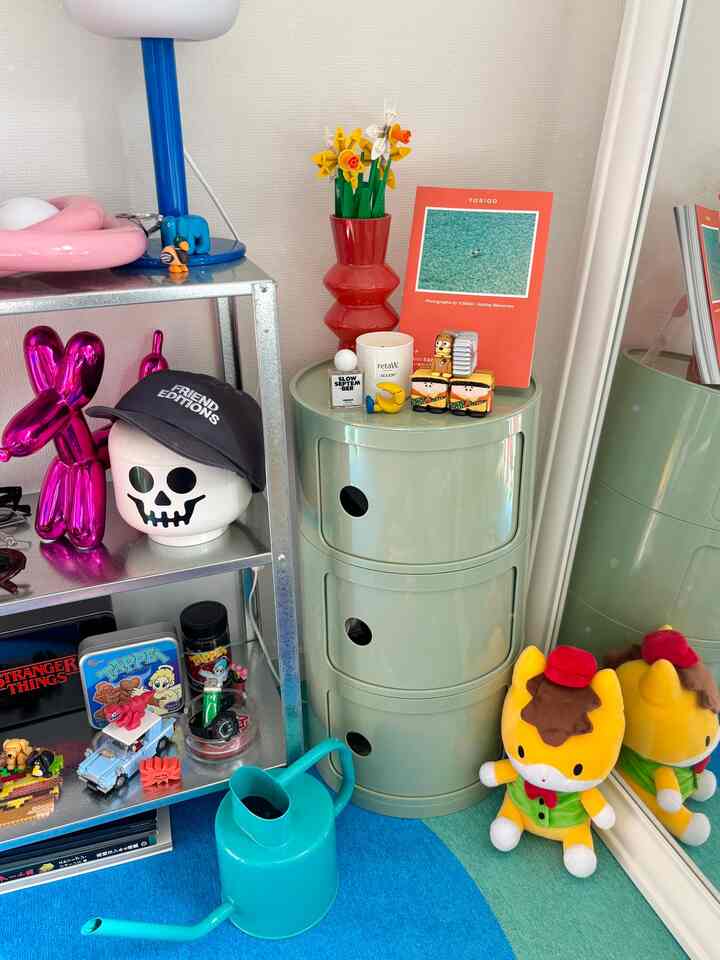 パステルミント色の円形キャビネットと金属棚が配置されたカラフルな子供部屋のコーナー