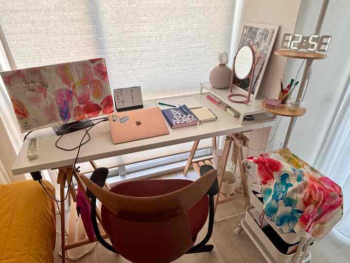 ホワイトと木目調のコンパクトなホームオフィス書斎空間、デスク上にノートパソコン、時計、鏡が配置された整った作業スペース