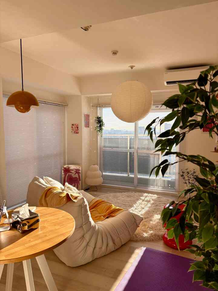 白と木目調が調和したリビング、ソファとペンダントライトが配置された温かみのある朝の空間