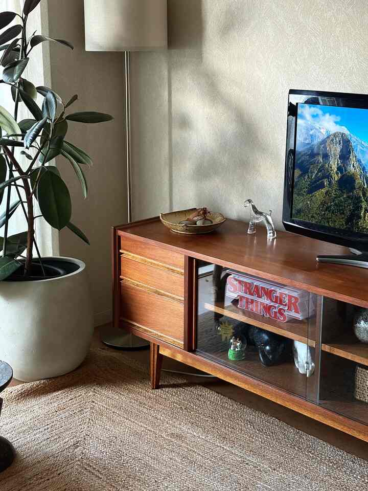 Natural color and wood tone living room featuring a wooden TV stand and floor lamp with a simple, natural atmosphere