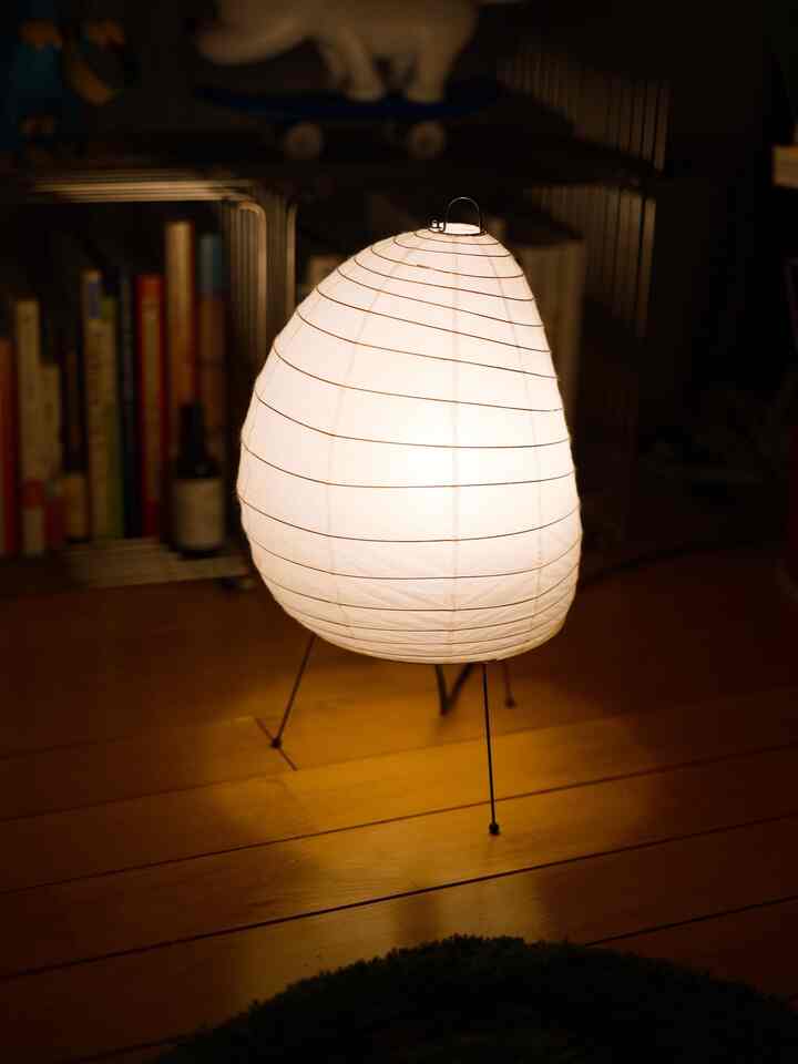 温かみのある木目調の床にアカリ1Aフロアランプが置かれた、居心地の良い1LDKワンルームの空間