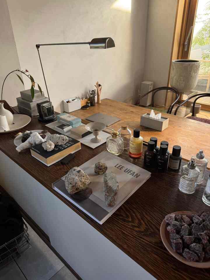 木目調のデスクが配置されたモダンなホームオフィス空間、植物とテーブルランプが調和する温かみのあるインテリア