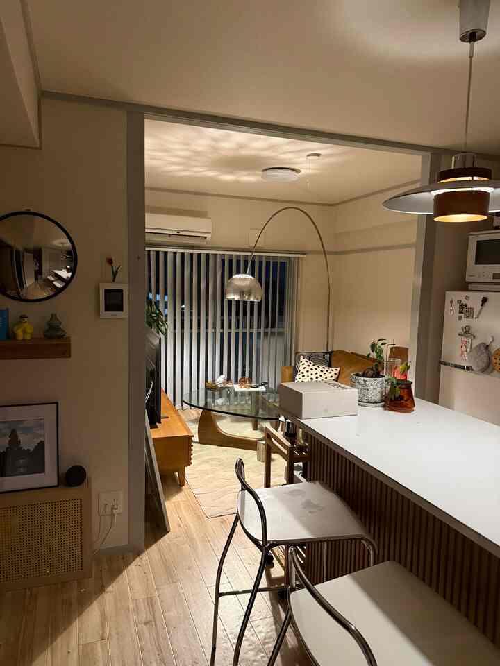 White and brown wood tone 2LDK apartment kitchen and living room featuring bar stools and glass table with cozy atmosphere