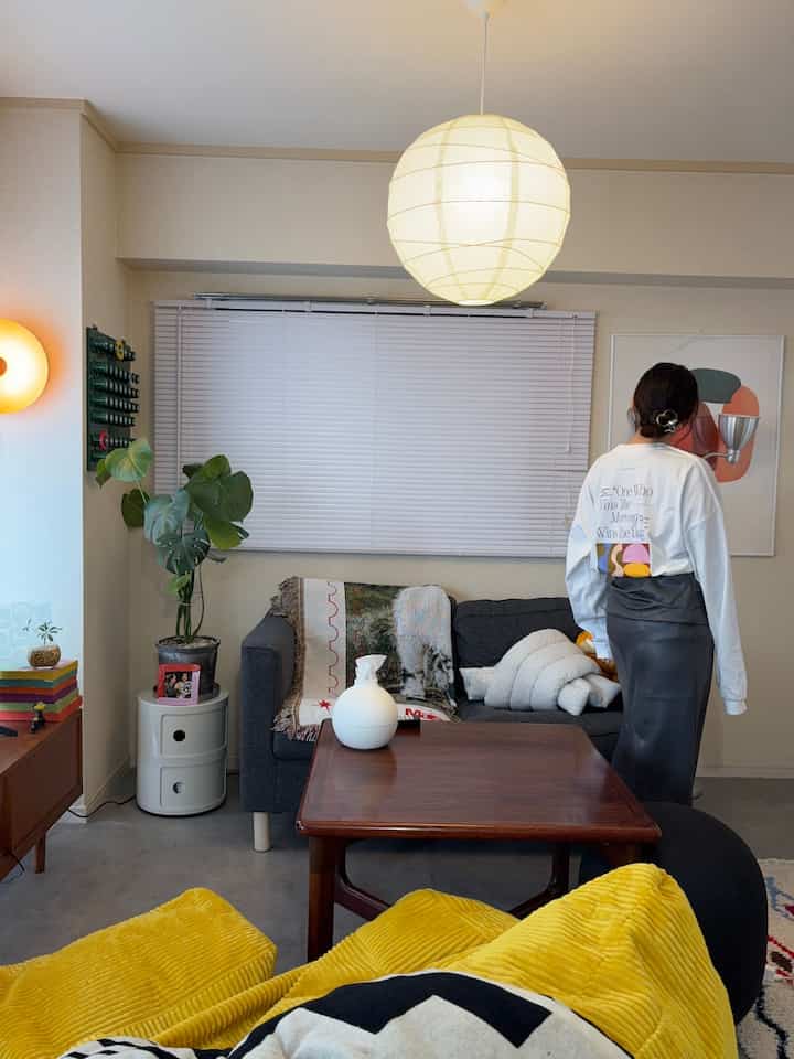 柔らかなホワイトとグレーの色調の12畳リビング、中央にダークウッドのコーヒーテーブルとグレーのソファが配置された居心地の良い空間