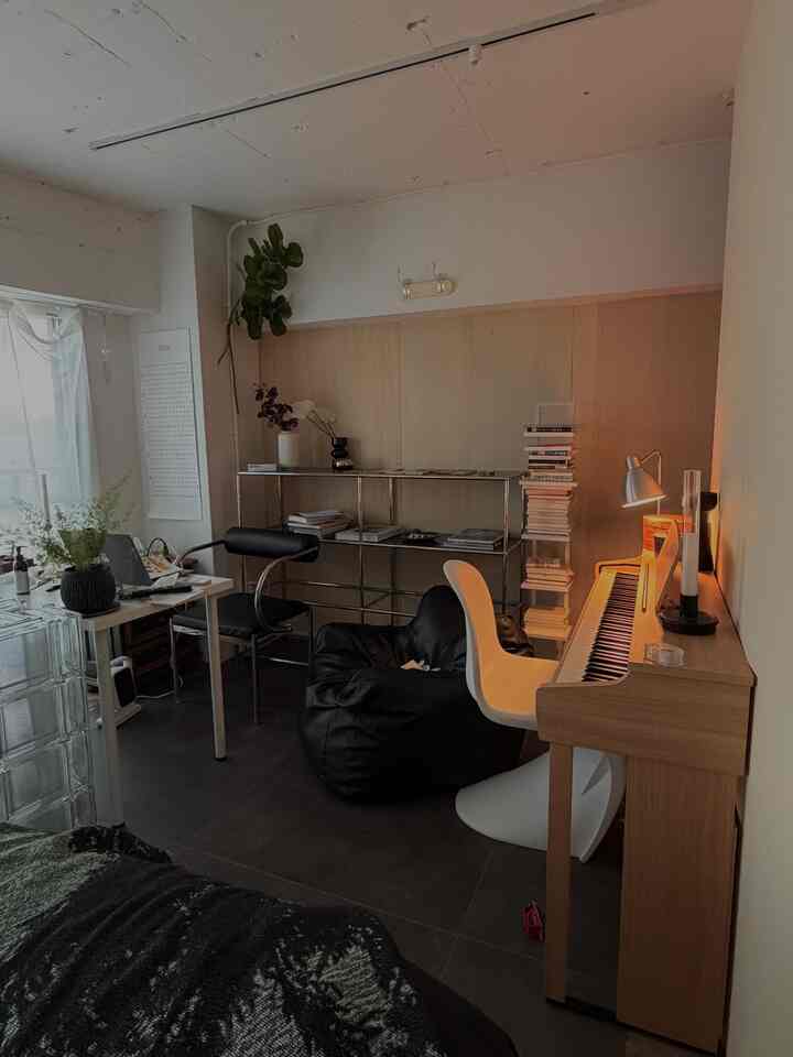 白と黒のトーンでまとめたナチュラルモダンなホームオフィス兼リラックススペース。右にピアノ、中央にビーンバッグチェア、左にデスクが配置された落ち着いた雰囲気のインテリア