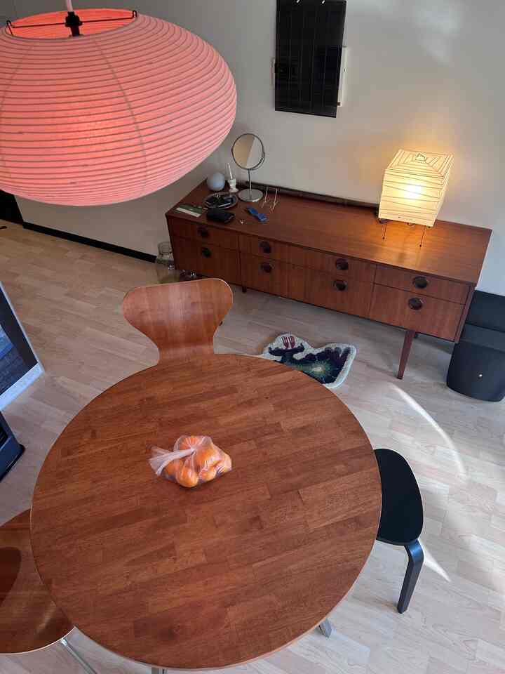 木目調のダイニングルーム、丸いダイニングテーブルとミッドセンチュリーモダン家具が配された雰囲気のあるインテリア