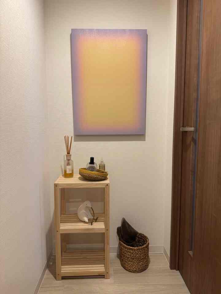 Beige walls with wooden shelf and abstract painting in a small entrance space