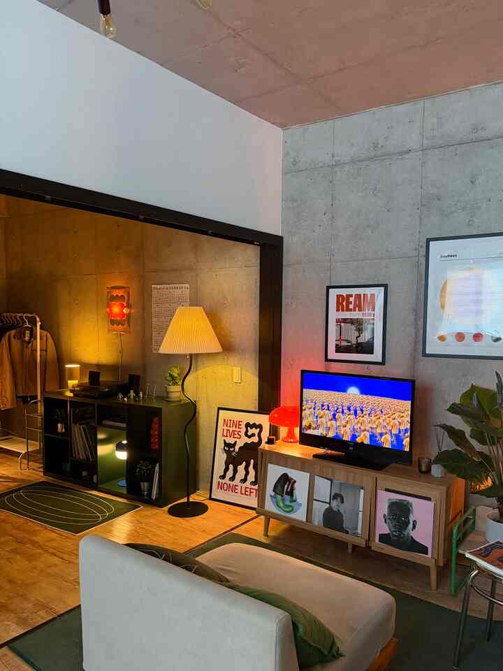 Beige and green toned living room featuring mid-century modern sofa, TV stand, and floor lamp creating cozy atmosphere