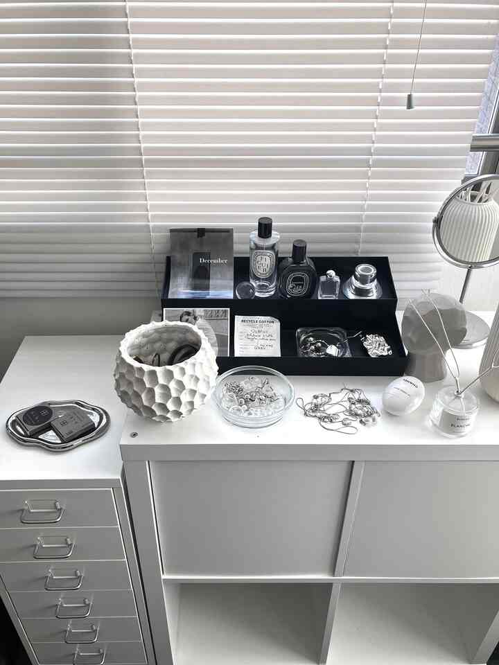 White-toned accessory storage space featuring organized jewelry and perfumes with a clean, simple interior vibe