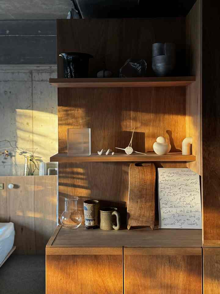 Warm wood tone dining room shelves with decorative objects illuminated by natural sunlight in vintage style