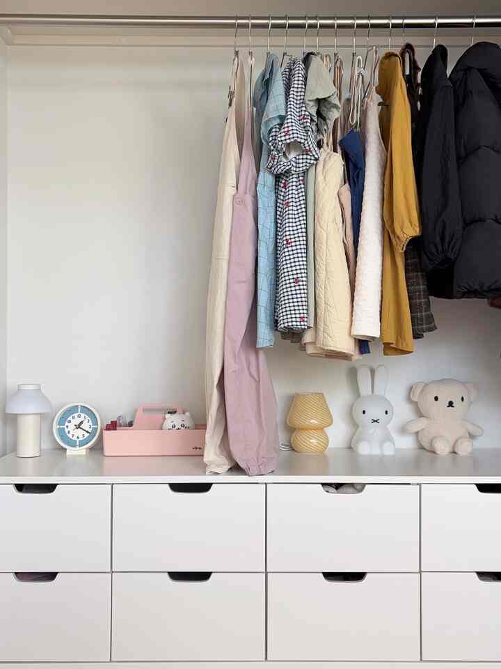 White-toned space featuring a clothing rack and dresser with a clean and cozy atmosphere