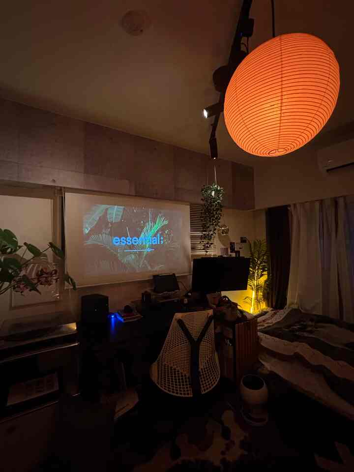 Warm orange-lit 8-tatami room for single household, featuring projector, computer desk, and modern home cinema atmosphere