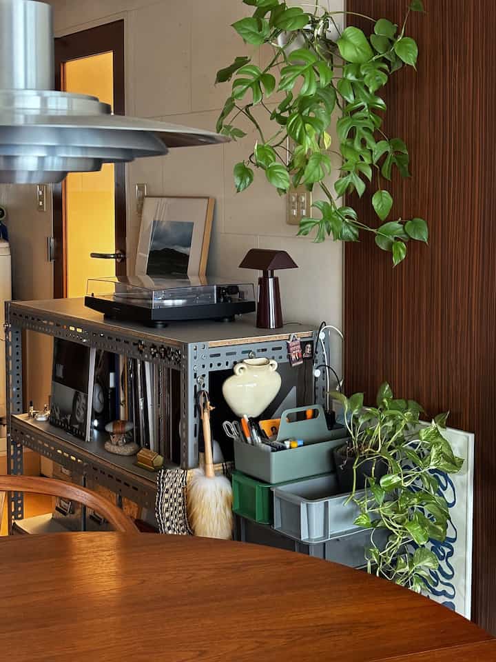 Natural-toned dining room featuring a wooden table, record player, and portable lamp creating a cozy atmosphere