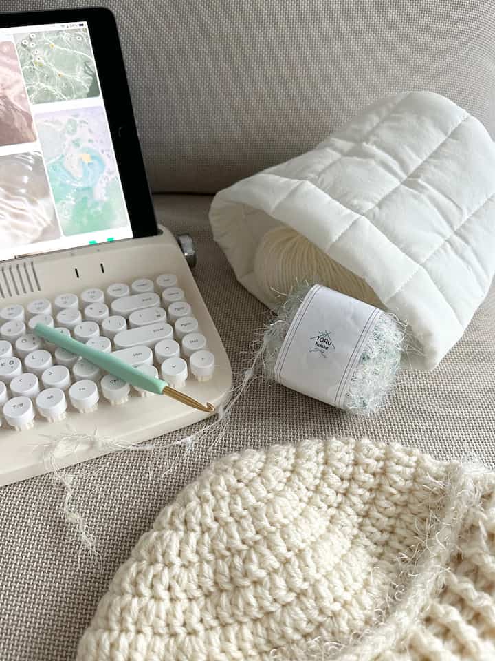 Beige-toned sofa featuring a cozy knitting setup with yarn and crochet hook, creating a warm and inviting atmosphere