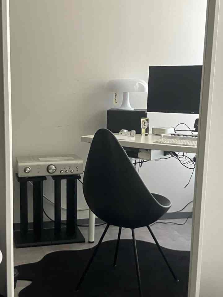 白と黒のトーンのホームオフィス、シンプルなデスクとアームチェアが配置されたミニマルな空間