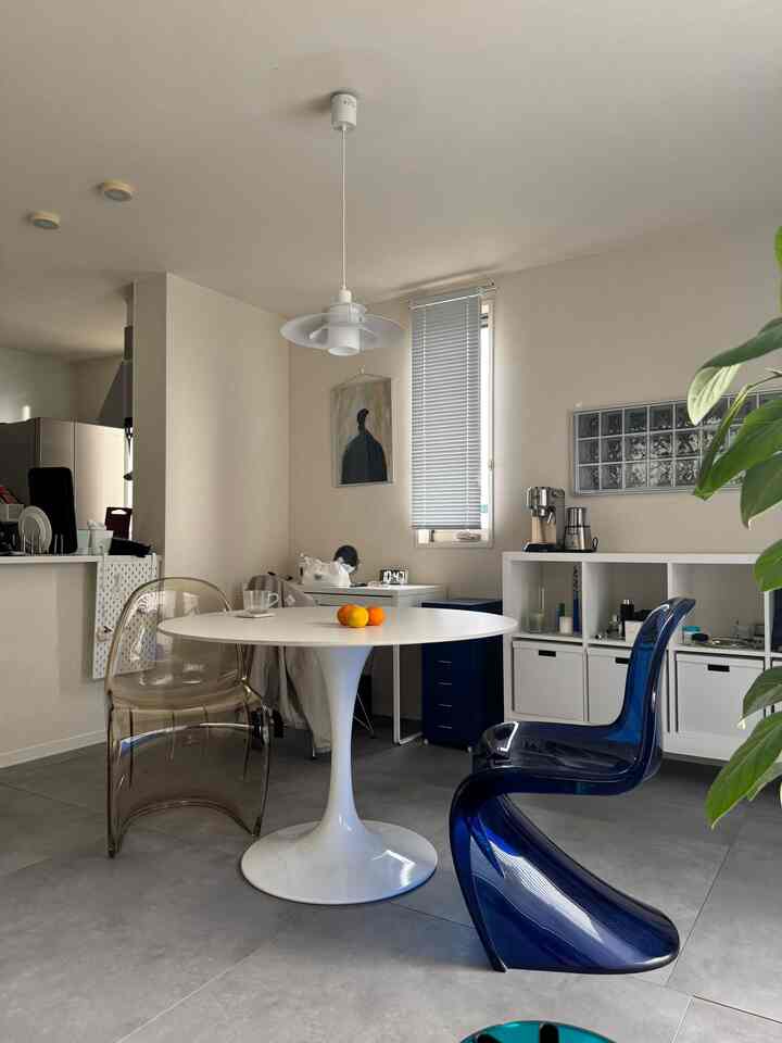 White and blue toned studio dining space featuring transparent chairs and a simple table with minimalistic style