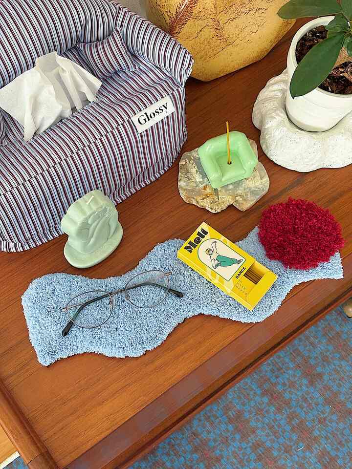 Korean interior style cozy decor featuring striped sofa tissue cover and blue table runner on wooden surface