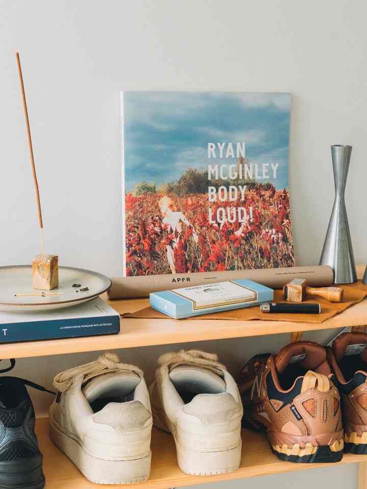 明るい木目調のシューズラックが置かれた玄関スペース、靴と小物が整頓されたシンプルで清潔なインテリア